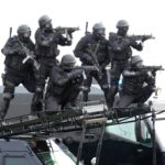 Kuwaiti police special forces ride on an armoured vehicle during a military parade in Subiya