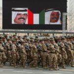 British armed forces pass by portraits o